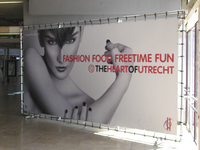 908348 Afbeelding van een grote reclamebanner met de tekst 'FASHION FOOD FREETIME FUN', in winkelcentrum Hoog ...